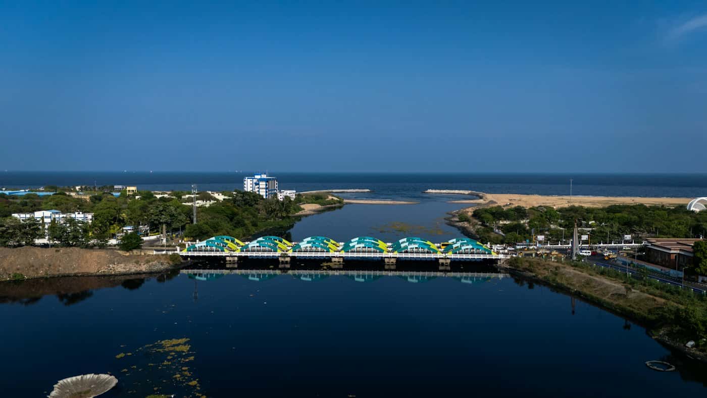 Aerial view of Napier Bridge over the Cooum river mouth in Chennai, with the sea beyond under a clear blue sky
